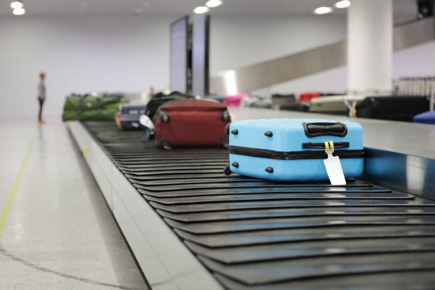 Pourquoi les gens se serrent autour du tapis à bagages à l’aéroport Image